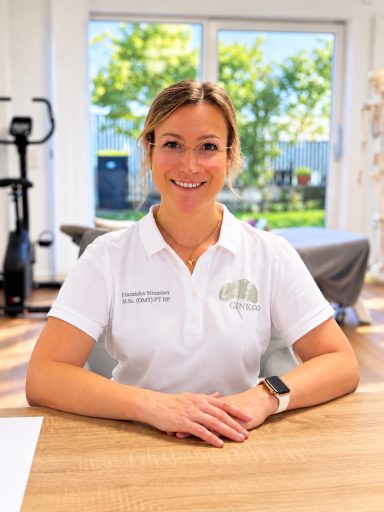 Porträt der Therapeutin sitzend am Tisch mit den Händen auf dem Tisch